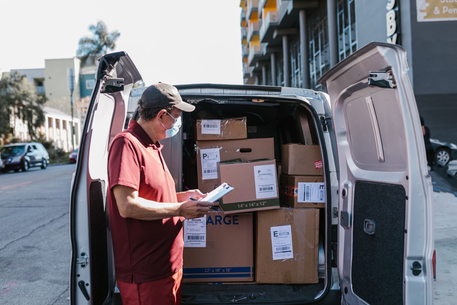 A field worker checking deliveries beside a vehicle